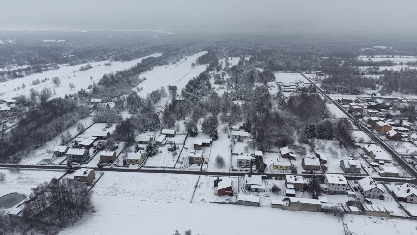 Snowy village road winding through rural homes