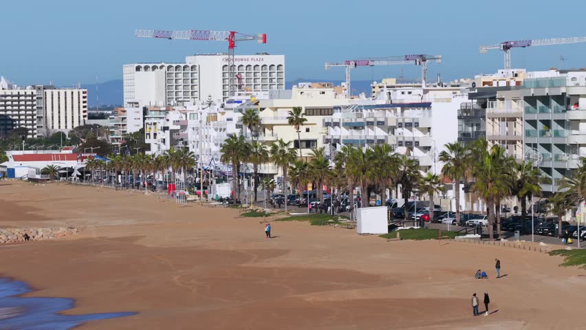 Cinematic 4K Aerial view of Quarteira Featuring Beachfront High-Rise Apartments, the Calçadão Promenade, and the Atlantic Horizon, Portugal	