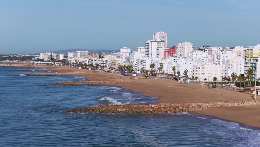 Cinematic 4K Aerial view of Quarteira Featuring Beachfront High-Rise Apartments, the Calçadão Promenade, and the Atlantic Horizon, Portugal	