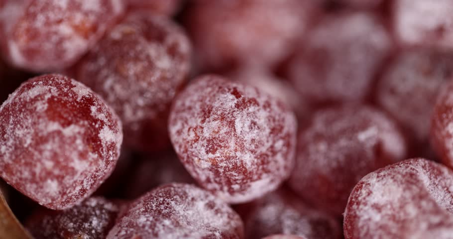 small orange fruits of fragrant kumquat in sugar syrup, food details, round dehydrated kumquat fruit in a wooden bowl