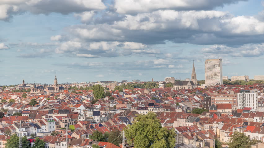 Aerial timelapse panorama over Brussels skyline in Schaerbeek near the railway station. Residential blocks, Saint-Servais Church and Town Hall surrounded by red rooftops in Belgium