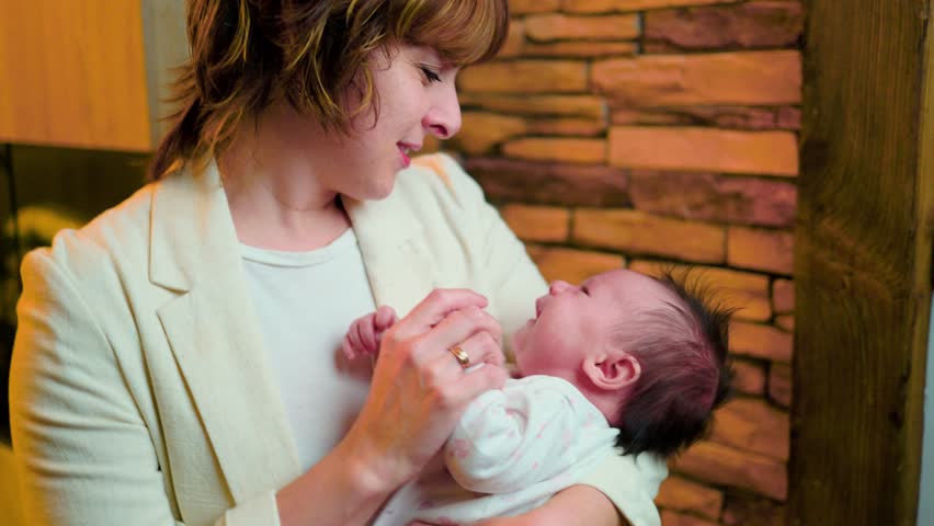 Affectionate mother cuddling her crying newborn baby