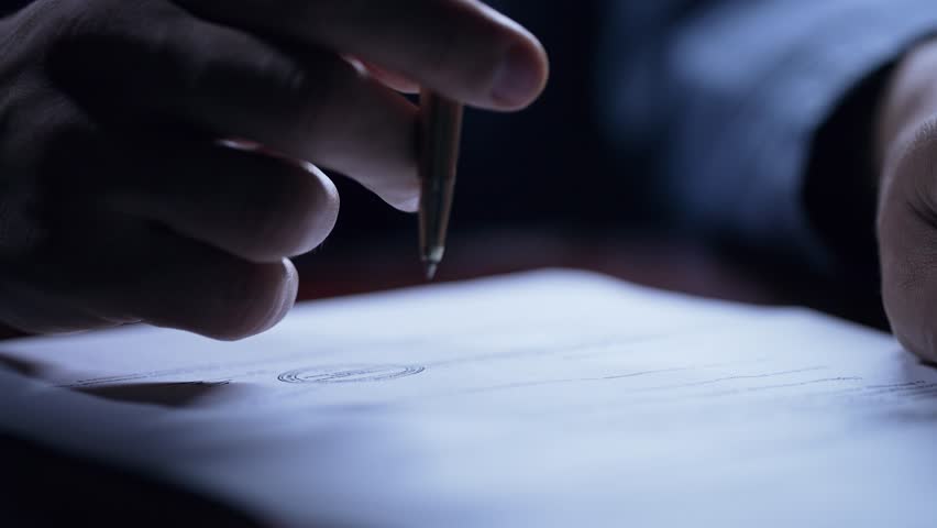 Man hesitating before signing important contract document