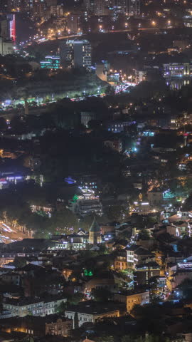 Colorful traditional houses with wooden carved balconies in the Old Town of Tbilisi aerial timelapse, Georgia. Illuminated buildings, cable car and traffic on a road