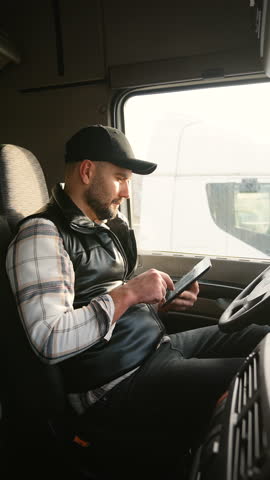 Truck driver using digital tablet in cabin