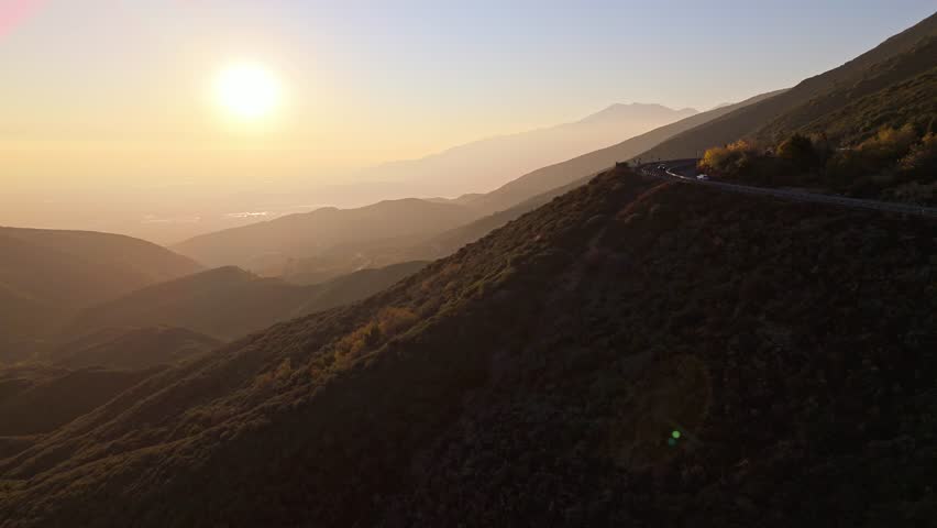 Aerial flyover of Panorama Point along the Rim of the World Scenic Byway at golden hour with colorful autumn foliage and majestic mountains in the San Bernardino National Forest