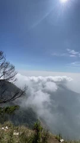 Mountain landscape covered with clouds under a blue sky