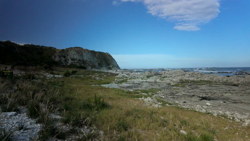 Coastal cliff above rocky flats and open ocean