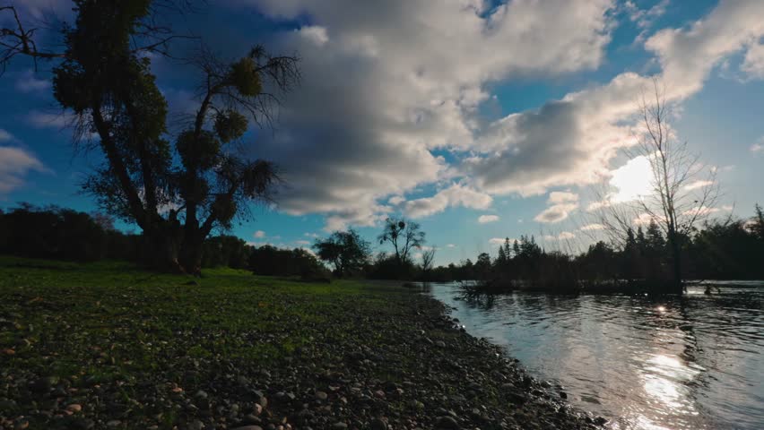 clouds and sun reflect across the American River at River Bend Park 