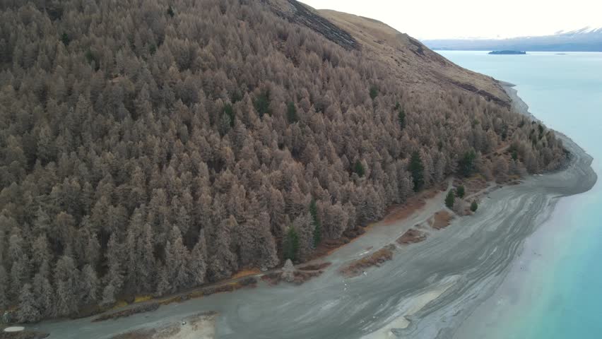 Drone footage of turquoise Lake Tekapo and mountains in South Island, New Zealand