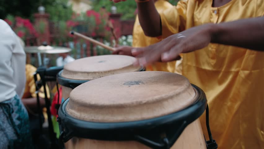 Close up of a drummer hands playing traditional conga drums during an outdoor festival. The artist beats a lively rhythm on the percussion instrument in Cambodia, Siem Reap