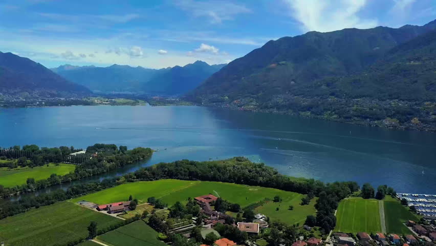 Aerial drone view of Ascona and Lake Maggiore in summer with blue sky and mountains, overlooking Castello del Sole
