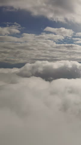 Aerial view: flying among clouds under bright sun. Fly between two layers cumulus clouds. Flies high in sky on between two levels puffy clouds. Natural scene with cloudy skies. Soar through heavens.