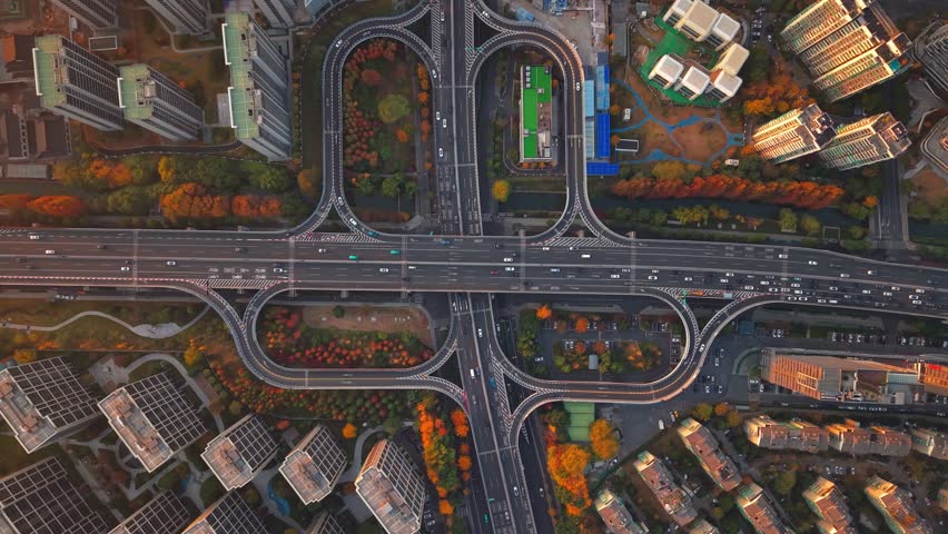 Aerial shot of complex freeway interchange with flowing traffic in Hangzhou, China during sunset.