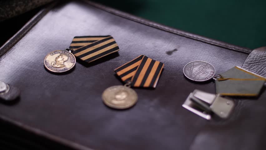 Vintage Soviet Union medals from world war ii, including the ribbon of saint George, lying on leather briefcase commemorating victory day and honoring the memory of military valor and patriotism.