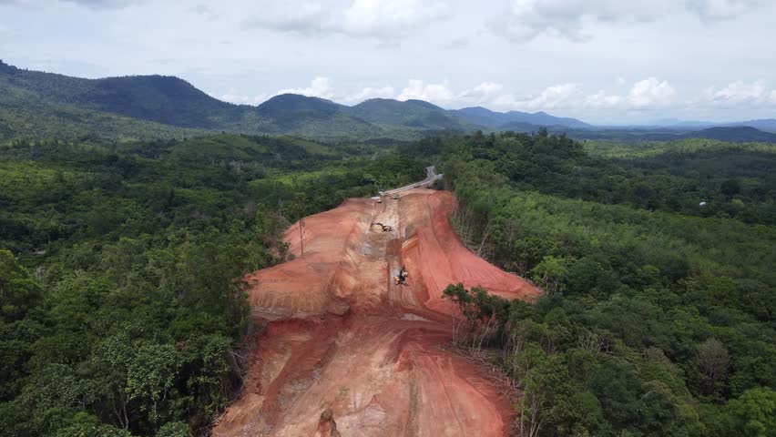 Aerial view of a mountain being excavated using an excavator for road construction