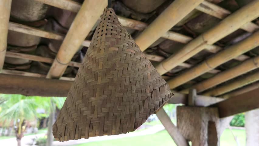 Decorative lights made from woven bamboo cone-shaped hats on the ceiling sway in the wind.