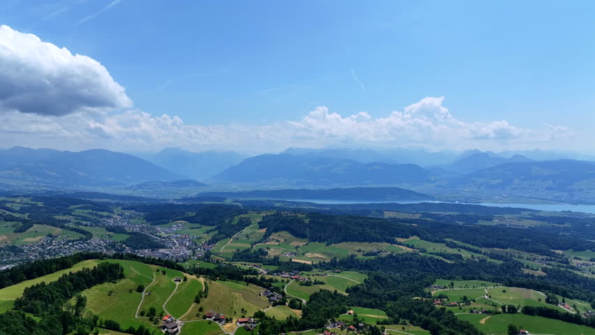 Scenic aerial drone footage of the Bachtel Tower in the Zurich Oberland, Switzerland. Summer landscape with blue sky, mountains and panoramic views