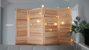 Smart light garland with woven balls on a wooden screen in a cozy living room, creating a warm ambiance.

 - Powered by Shutterstock - Get 15% off with code: PIKWIZARD15