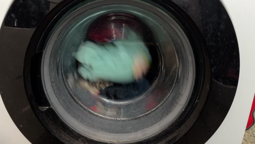 Washing Clothes Spinning Through Soap, Modern Laundry Appliance Spinning Vibrant Clothes With Soapy Suds