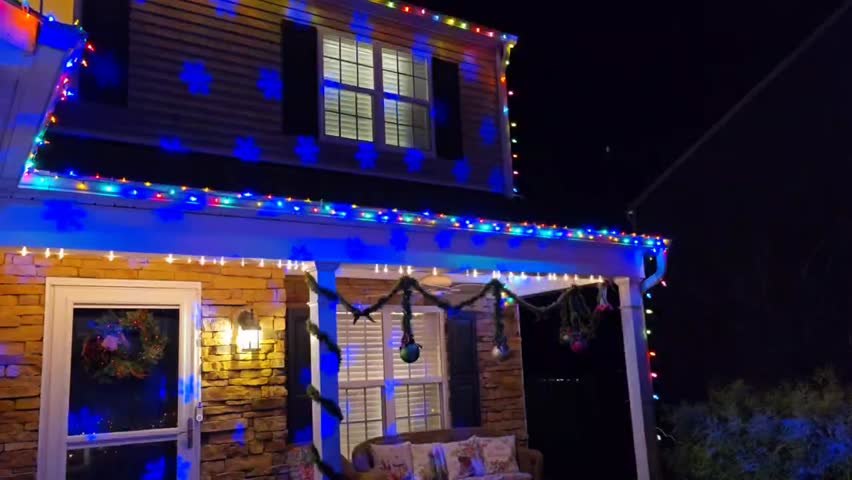 Christmas house with holiday lights at night. Suburban house decorated with bright Christmas lights and holiday decorations at night. Festive winter atmosphere, seasonal holiday exterior, no people, suitable for Christmas and New Year projects.