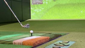Slow motion close-up of golf club hitting ball on indoor simulator mat with projection - Powered by Shutterstock - Get 15% off with code: PIKWIZARD15