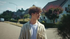 Young male casually walking through suburb environment, Teenager with casual walk along manicured suburban streets, Young male enjoying relaxed walk amid friendly community and sunny - Powered by Shutterstock - Get 15% off with code: PIKWIZARD15