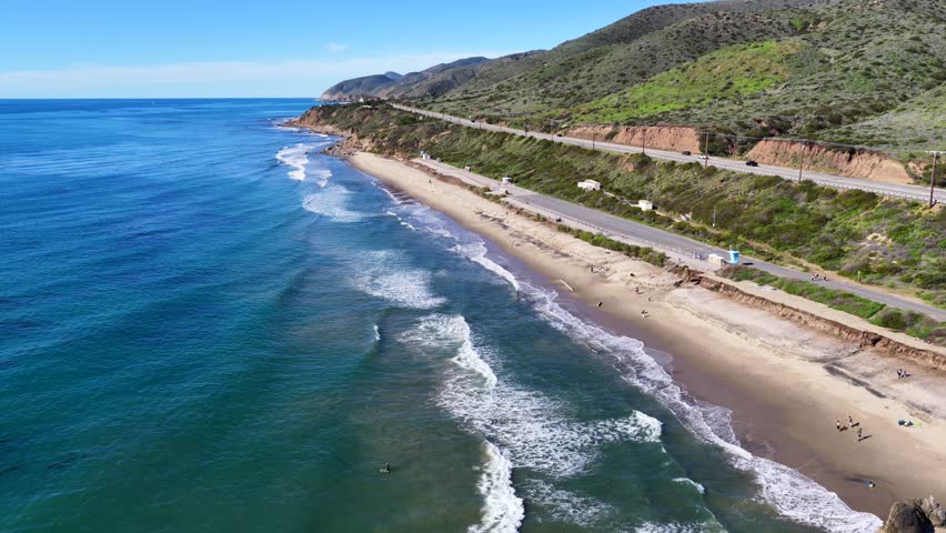 4K video of Leo Carrillo State Beach in Malibu, featuring sandy shoreline, rocky outcrops, and Pacific Ocean waves along the Southern California coast on a clear winter day.