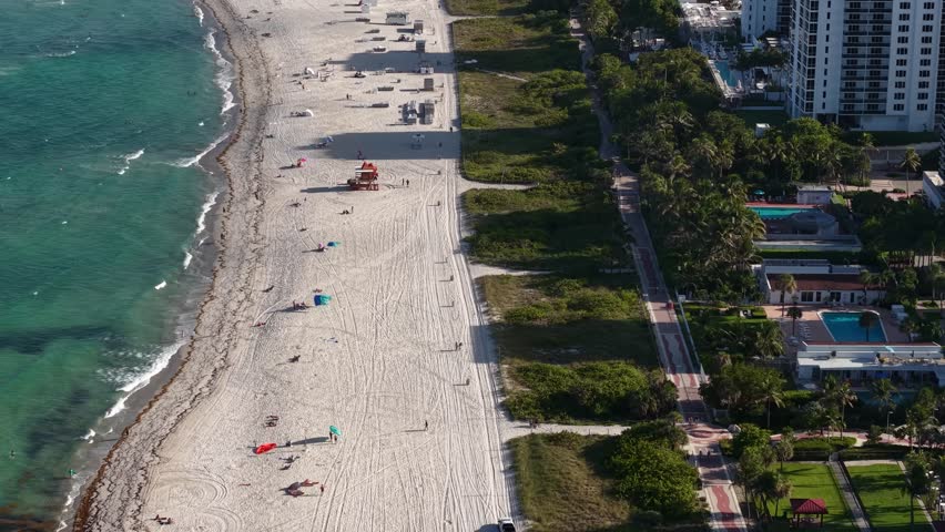 Revealing Drone Shot of South Beach Miami, Florida USA, Waterfront Buildings and People on Sandy Shore
