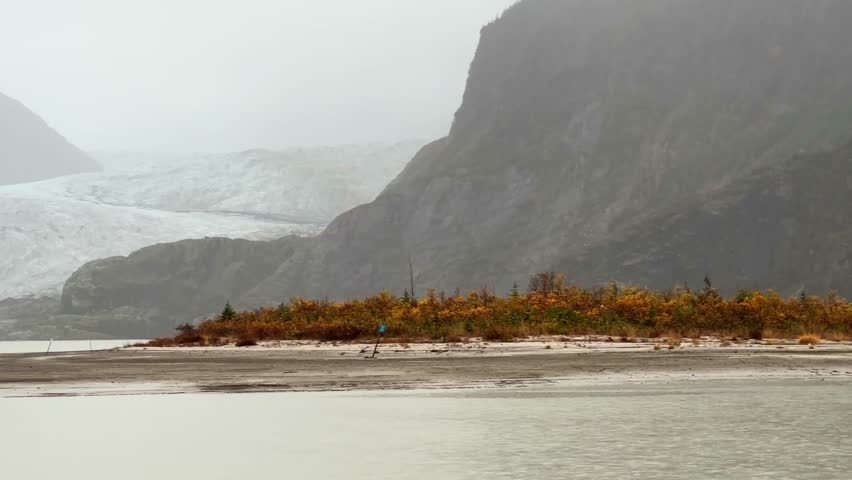 Handheld telephoto panning shot of retreating Mendenhall Glacier during the autumn season in Juneau, Alaska. 4K