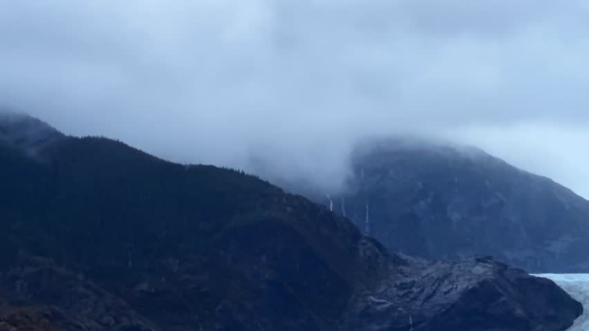 Handheld telephoto booming down shot of the famous Mendenhall Glacier on a misty fall day in Juneau, Alaska. 4K