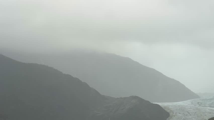 Handheld telephoto booming down shot of the incredible Mendenhall Glacier, which is slowly retreating from the lake in Tongass National Forest, Alaska. 4K