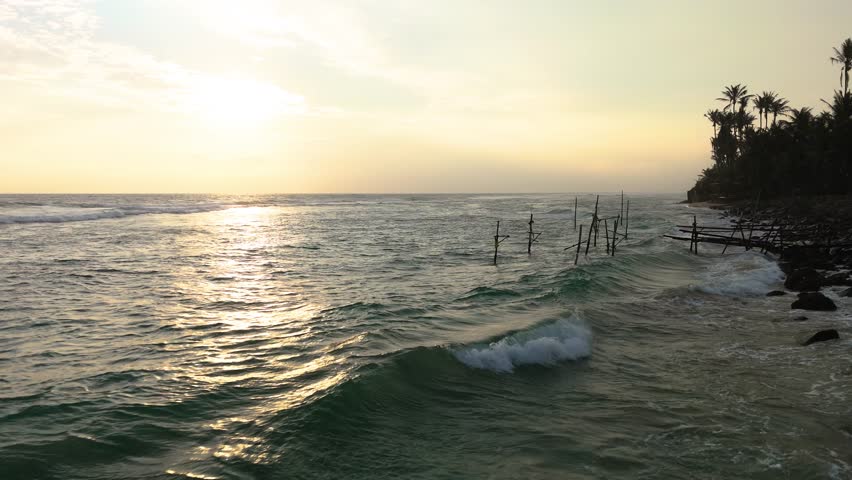 Fly over sea next to coast, view of empty stilt fishing, Sri Lanka