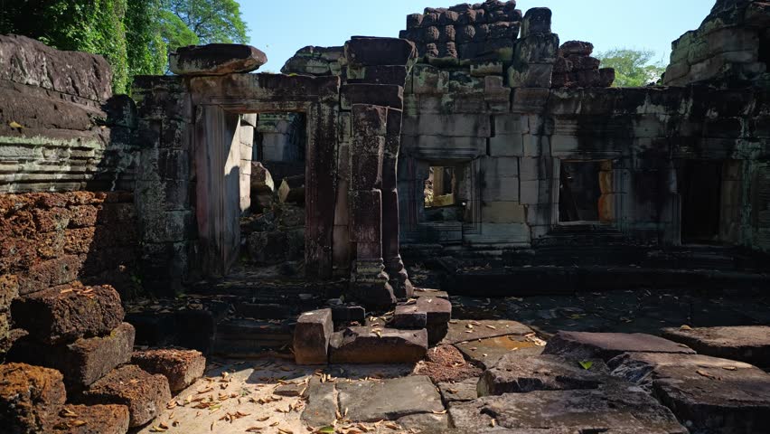 Slow pan right through the stone interior of Preah Khan Temple, showing ancient corridors, carved doorways, and weathered ruins in Siem Reap