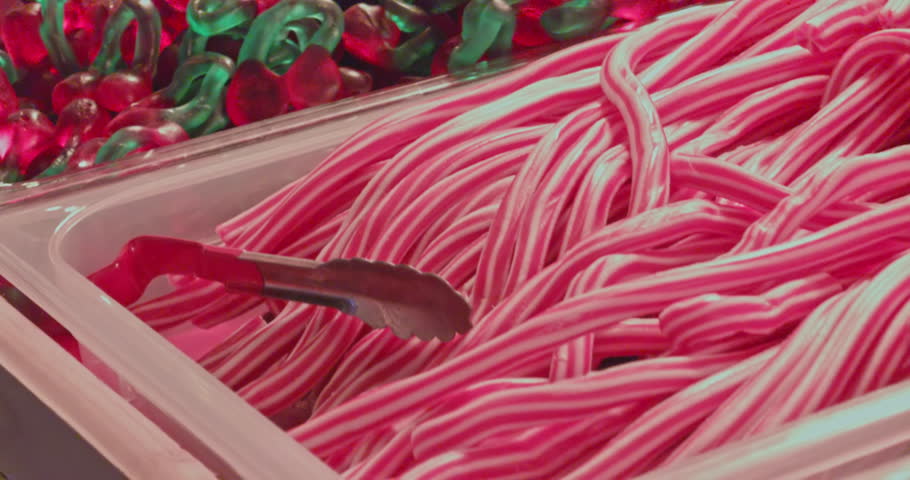 colorful numerous various mixed candies marmalade jelly beans marshmallows sweets lollipops in trays, closeup view of confectionery products
