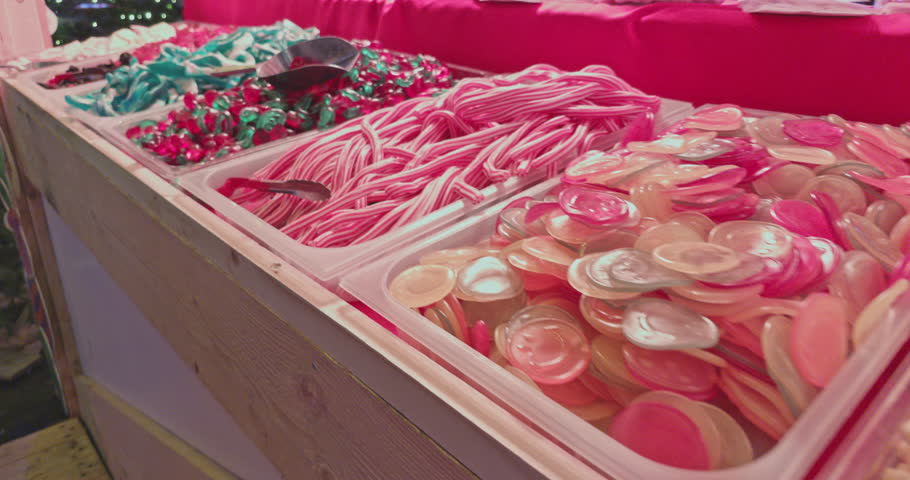 colorful numerous various mixed candies marmalade jelly beans sweets lollipops in trays, closeup view of confectionery products for kids
