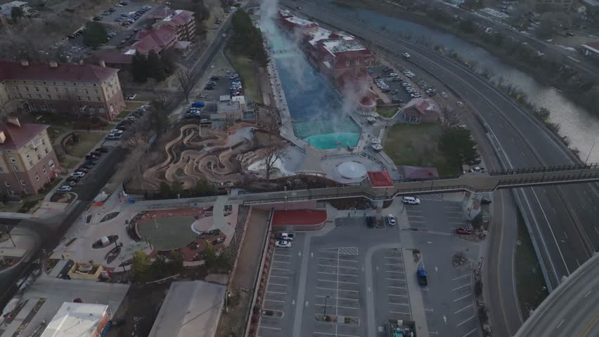 Aerial drone footage flying straight toward Glenwood Springs, Colorado, revealing the mountain town and surrounding valley. Scenic Rocky Mountain city approach captured in daylight.