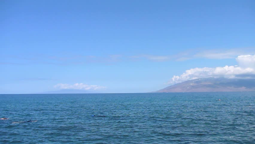 People snorkeling in Maui, Hawaii on sunny day.