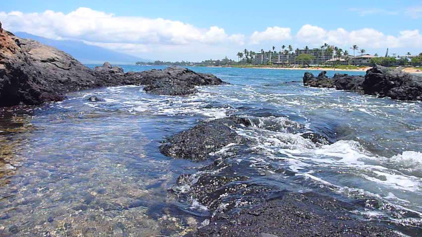 Tide coming in, washing over coral reef creating tide pools in Hawaii, time