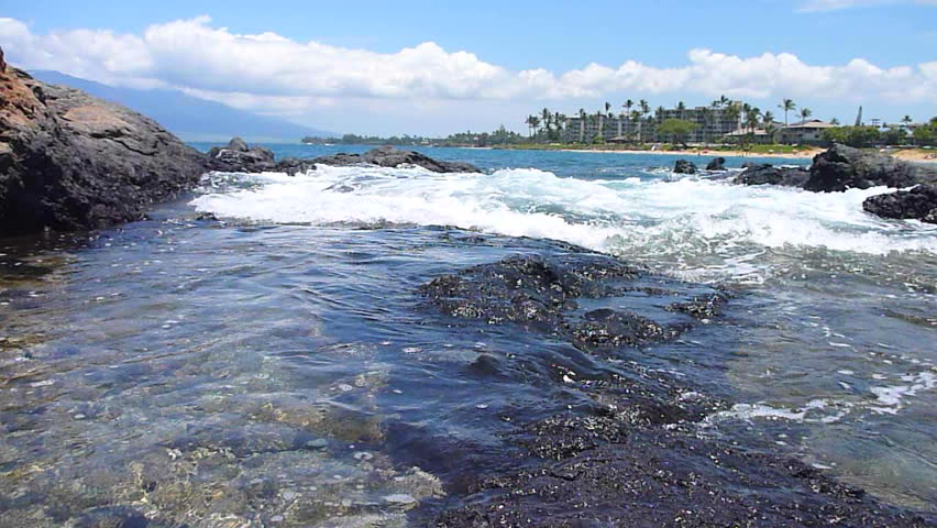 Tide coming in, washing over coral reef creating tide pools in Hawaii.