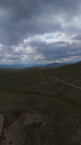 Aerial view of the vast Deosai Plains under a dramatic sky, where the landscape