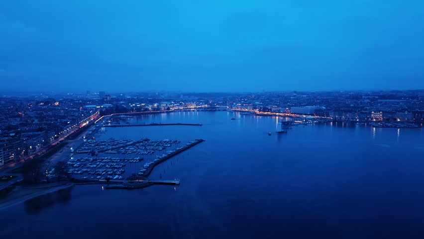 Aerial view of the city lights reflecting on the tranquil Geneva lake, creating a mesmerizing scene of urban beauty, Rade of Geneva, Geneva, Switzerland.
