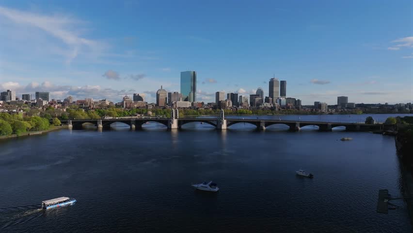 Aerial view of the Boston skyline with the John Hancock Tower and a bridge over the Charles River, reflecting the sky, Boston, Massachusetts, United States.