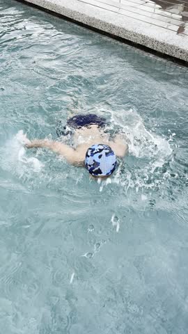 An Asian boy enjoying his holiday by swimming at the apartment