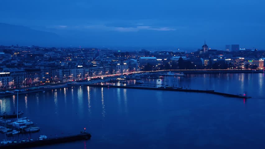 Aerial view of Quai Gustave-Ador at night where lights shimmer on the water
