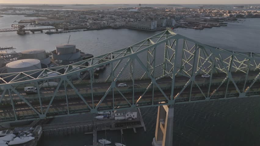 Aerial view of the Tobin Bridge spanning the dark waters, connecting to the cityscape beyond, a contrast of steel and urban sprawl, Boston, Massachusetts, United States.