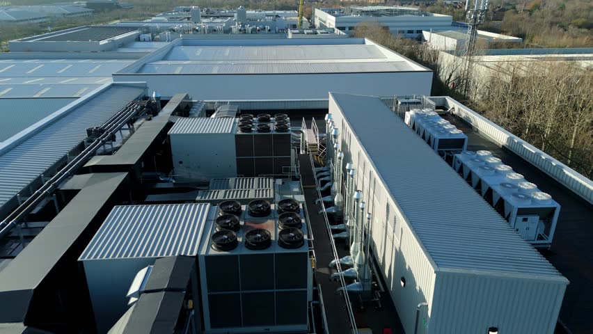 Aerial view of assorted rooftop HVAC systems with silver ducting creating a geometric industrial landscape, Milton Keynes, England, United Kingdom.