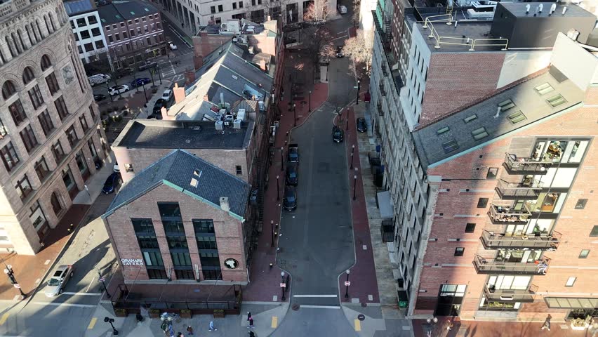 Aerial view of the urban landscape with brick buildings, streets, and cars creating a dense and intricate scene under the sunlight, Boston, Massachusetts, United States.