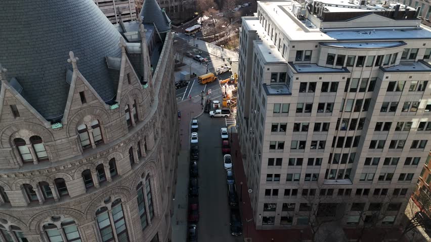 Aerial view of the urban landscape showing buildings, streets, vehicles, and a construction site with heavy machinery, Boston, Massachusetts, United States.