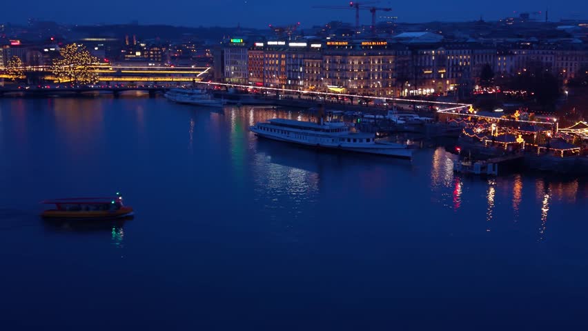 Aerial view of boats sailing on Lake Geneva in La Rade, with lights shimmering against the dark water and illuminating the city, Geneva, Geneva, Switzerland.